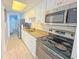 Bright kitchen with white cabinets, granite counters, and stainless steel appliances, with a peek to another room at 7200 N Ocean Blvd. # 1160, Myrtle Beach, SC 29572