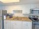 A kitchen featuring white cabinets, granite countertops, stainless steel appliances, and a double sink at 7200 N Ocean Blvd. # 1160, Myrtle Beach, SC 29572