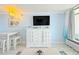 Cozy living area features a TV, white cabinet, a dining table and balcony access, all bathed in soft, natural light at 7200 N Ocean Blvd. # 1160, Myrtle Beach, SC 29572