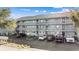 Three-story condo building with gray siding, multiple balconies, and convenient parking spaces at 7700 Porcher Dr. # 3207, Myrtle Beach, SC 29572