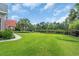 Backyard with a large lawn, pond view, and lush landscaping, creating a serene outdoor space at 8013 Wacobee Dr., Myrtle Beach, SC 29579