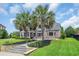 Exterior of a well-maintained brick home with manicured lawn, palm trees, and tasteful landscaping at 8013 Wacobee Dr., Myrtle Beach, SC 29579