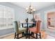 Cozy dining area features a modern table, stylish chairs, and elegant lighting, complemented by natural light from shuttered windows at 864 Barn Owl Ct. # 864, Myrtle Beach, SC 29579