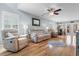 Inviting living room with plush reclining sofas, hardwood floors, ceiling fan, and access to the dining area through glass doors at 864 Barn Owl Ct. # 864, Myrtle Beach, SC 29579