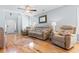 Bright living room featuring comfortable sofas, hardwood floors, ceiling fan, and a charming decorative mirror at 864 Barn Owl Ct. # 864, Myrtle Beach, SC 29579