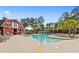 Inviting swimming pool with lounge chairs, palm trees, and a charming red barn-style building, a perfect community amenity at 864 Barn Owl Ct. # 864, Myrtle Beach, SC 29579