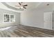 Bright bedroom featuring a ceiling fan, tray ceiling, and wood-look floors at 1004 Woodside Dr., Conway, SC 29526