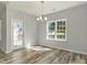 Light-filled dining area with a modern chandelier and large windows overlooking the backyard at 1004 Woodside Dr., Conway, SC 29526