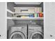 A convenient laundry room with storage shelves, featuring modern washer and dryer units for efficient laundry care at 10301 North Kings Hwy. # 21-4, Myrtle Beach, SC 29572