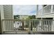 Balcony with white railings and view of palm trees, other buildings, and a parking lot at 130 Puffin Dr. # 2B, Pawleys Island, SC 29585
