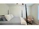 Bedroom features a four-poster bed with gray bedding and cozy sitting chair near a window at 130 Puffin Dr. # 2B, Pawleys Island, SC 29585