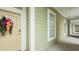 Exterior hallway featuring neutral paint, adjacent windows, and a decorative wreath on front door at 130 Puffin Dr. # 2B, Pawleys Island, SC 29585