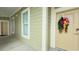 Exterior hallway with adjacent windows, neutral paint, and a wreath on front door at 130 Puffin Dr. # 2B, Pawleys Island, SC 29585