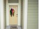 Charming front door with a 'hello' door mat and a decorative wreath, with neutral paint at 130 Puffin Dr. # 2B, Pawleys Island, SC 29585