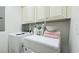 Laundry room features side-by-side washer and dryer units and cream-colored cabinets at 130 Puffin Dr. # 2B, Pawleys Island, SC 29585