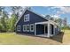 Side exterior view of a modern navy blue home with white trim and inviting porch at 1852 Hardwood Ct., Conway, SC 29526