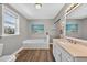 This traditional bathroom offers a tub, a window, vanity, and beach-themed decor for a soothing aesthetic at 1885 Pompano Dr., Garden City Beach, SC 29576