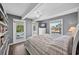 Bedroom with hardwood floors, large windows providing ample light, a ceiling fan, and balcony access at 1885 Pompano Dr., Garden City Beach, SC 29576