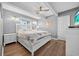 Comfortable bedroom with ceiling fan, hardwood floors, and ample natural light from the large window at 1885 Pompano Dr., Garden City Beach, SC 29576