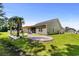 Exterior view of the home featuring a backyard with a stone patio, wooden pergola, and lush lawn at 216 Palm Terrace Loop, Conway, SC 29526