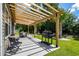 Backyard with a wooden pergola over a patio, a grill, and well-manicured landscaping at 216 Palm Terrace Loop, Conway, SC 29526