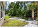 Spacious backyard with a stone patio, lush lawn, and mature trees, perfect for outdoor activities at 216 Palm Terrace Loop, Conway, SC 29526