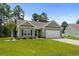 Charming one-story home featuring well-kept lawns and landscaping, with a two-car garage at 216 Palm Terrace Loop, Conway, SC 29526
