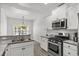 Updated kitchen features stainless steel appliances and granite counters with modern backsplash at 216 Palm Terrace Loop, Conway, SC 29526