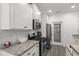 Modern kitchen featuring granite counters, stainless appliances, and white cabinetry at 216 Palm Terrace Loop, Conway, SC 29526