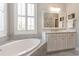 Bright bathroom featuring a soaking tub, marble countertops, and elegant white cabinetry at 226 Red Tail Hawk Loop, Pawleys Island, SC 29585
