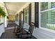 Relaxing front porch features two rocking chairs, dark shutters, and a view of the yard at 226 Red Tail Hawk Loop, Pawleys Island, SC 29585