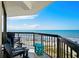 Relax on this balcony with chairs and a table overlooking a scenic beach and ocean view on a sunny day at 2501 S Ocean Blvd. # 508, North Myrtle Beach, SC 29582