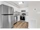 Well-lit kitchen with stainless steel appliances, white cabinets, and wood-look flooring at 301 N Waccamaw Dr. # 311, Garden City Beach, SC 29576