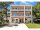 Stunning three-story stilt home featuring an outdoor staircases and charming porch on all levels at 3304 Palm St., North Myrtle Beach, SC 29582