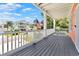 A spacious porch featuring a gray wood floor, white railings, and views of a charming street at 3304 Palm St., North Myrtle Beach, SC 29582