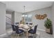 Staged dining room with natural lighting and wooden table, enhanced by a decorative pendant light at 4490 Barcelona Ln., Little River, SC 29566