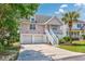 Charming two-story home features a two-car garage and a staircase leading to the front porch entry at 4490 Barcelona Ln., Little River, SC 29566