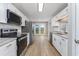Bright kitchen with stainless appliances, granite countertops, and white cabinetry, next to exterior door access at 4490 Barcelona Ln., Little River, SC 29566