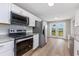 Modern kitchen featuring stainless steel appliances, white cabinetry, granite countertops, and exterior patio access at 4490 Barcelona Ln., Little River, SC 29566