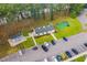 Aerial view of the community clubhouse with a mini-golf course and parking lot surrounded by tall trees at 493 White River Dr. # 28-D, Myrtle Beach, SC 29579