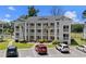Three-story condo building featuring white exteriors, balconies, manicured landscaping, and convenient parking at 493 White River Dr. # 28-D, Myrtle Beach, SC 29579