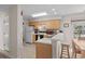 Efficient kitchen features wood cabinets, white countertop and backsplash, bar seating, and appliances at 493 White River Dr. # 28-D, Myrtle Beach, SC 29579