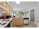 Kitchen with view into the living room, featuring wooden cabinetry, stainless steel appliances, and modern lighting at 493 White River Dr. # 28-D, Myrtle Beach, SC 29579