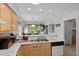 Kitchen with view into the living room, featuring wooden cabinetry, stainless steel appliances, and modern lighting at 493 White River Dr. # 28-D, Myrtle Beach, SC 29579