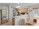 Efficient kitchen features wood cabinets, white countertop and backsplash, bar seating, and appliances at 493 White River Dr. # 28-D, Myrtle Beach, SC 29579