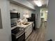 Well-equipped kitchen features modern stainless steel appliances, white cabinetry, and breakfast bar at 504 Ocean Blvd. N # 410, Myrtle Beach, SC 29577