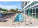 Outdoor pool with lounge chairs surrounded by tropical palm trees at 504 Ocean Blvd. N # 410, Myrtle Beach, SC 29577