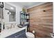 Well-lit bathroom featuring wood-look paneling and gray vanity at 5511 N Ocean Blvd. # 902, Myrtle Beach, SC 29577