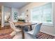 Dining area with a wooden table, white wicker chairs, bright rug, and natural light from a large window at 640 Mccorkle Place, Conway, SC 29526