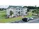 Exterior view of the condo building showing balconies, landscaping, and parking at 697 Tupelo Ln. # 24G, Longs, SC 29568